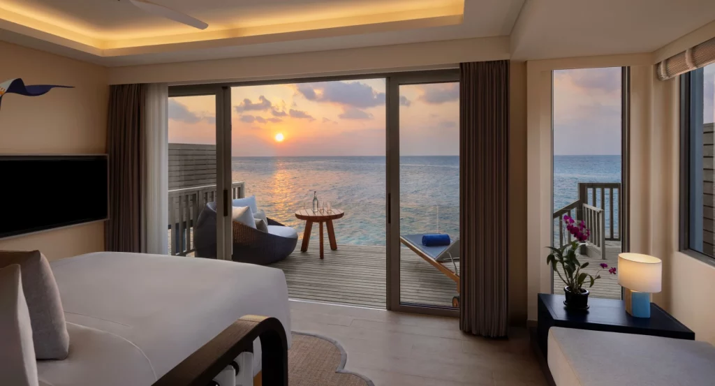 avani_sunset_over_water_villa_bedroom_avani_plus_fares_maldives_resort_1920x1037